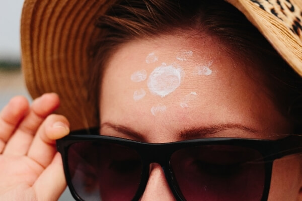 額に日焼け止めを塗る女性